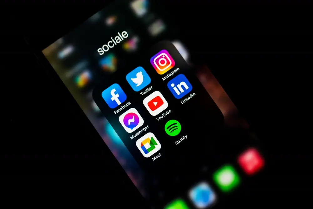 Teléfono mostrando íconos de Instagram, Facebook, YouTube y otras redes sociales