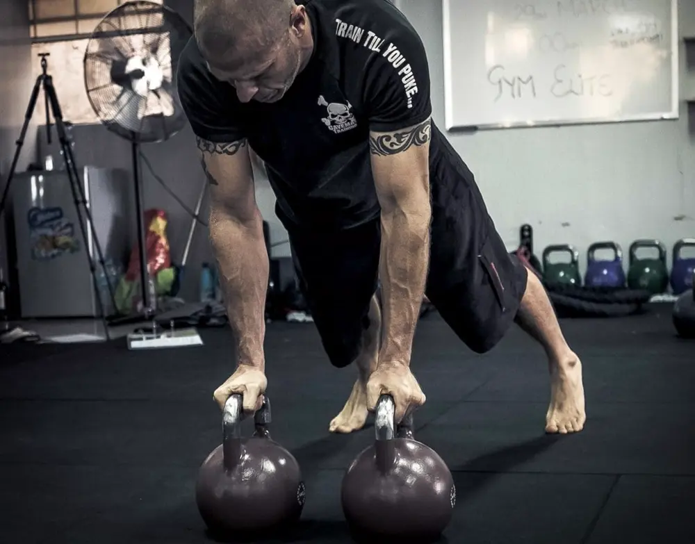Hombre entrenando fuerza con pesas rusas en gimnasio, referencia al contenido fitness en Instagram Mexico