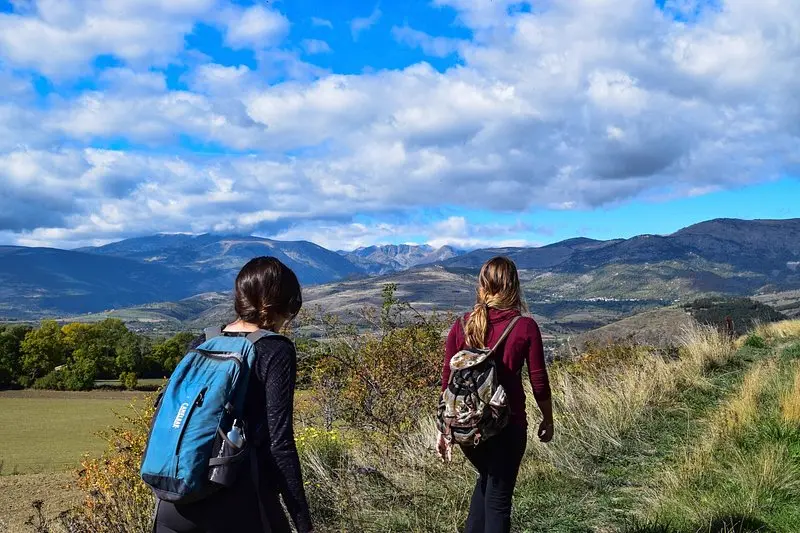 Dos personas con mochila de trekking observando un valle montanoso, referencia al estilo de vida y los vlogs de viaje que comparte contenido lifestyle en Instagram Mexico