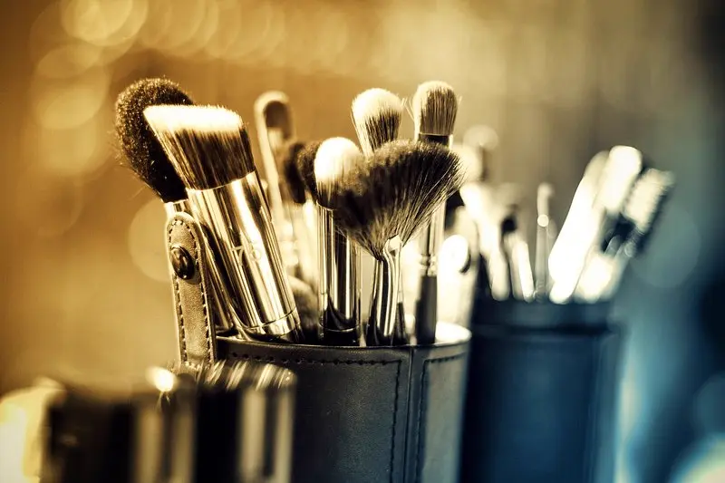 Set de brochas de maquillaje profesional sobre fondo con luces calidas, referencia al servicio de belleza y microblading que ofrece una creadora de Instagram en Mexico