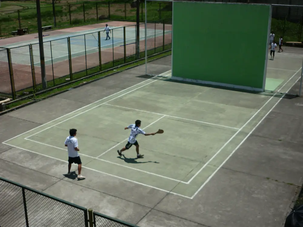 Partido de frontenis en una cancha de frontón al aire libre, referencia al contenido deportivo de @tuliorodca en Instagram México