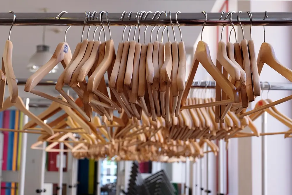 Ganchos de madera colgados en un perchero de tienda de ropa, referencia al contenido de moda y outfits en Instagram México