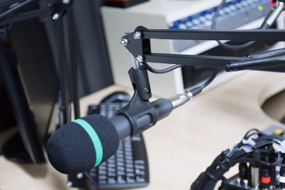 Micrófono de estudio de radio sobre un brazo articulado, referencia al trabajo de locución de Hana Chavarría en México