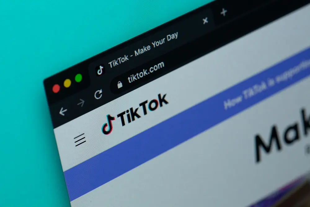 Persona viendo TikTok en una laptop, referencia a comprar seguidores de TikTok y el shadowban en México